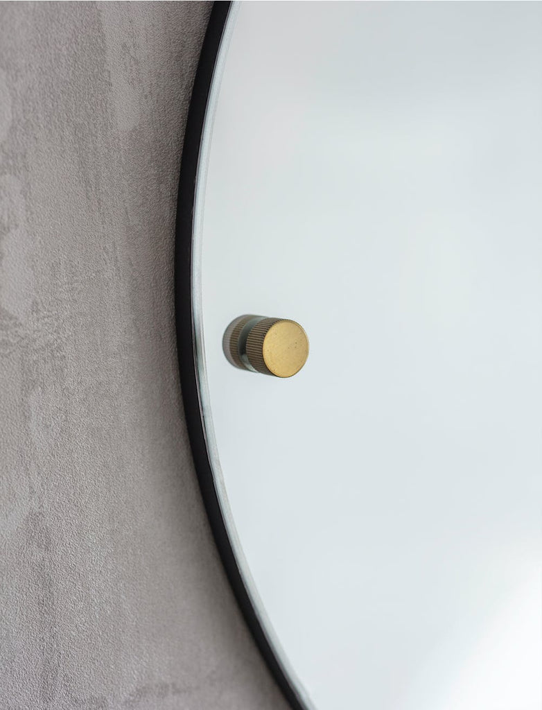 large round mirror with brass detail 