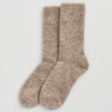 A pair of fuzzy, heathered knit socks in a warm taupe-beige color, displayed flat against a clean, light gray background.