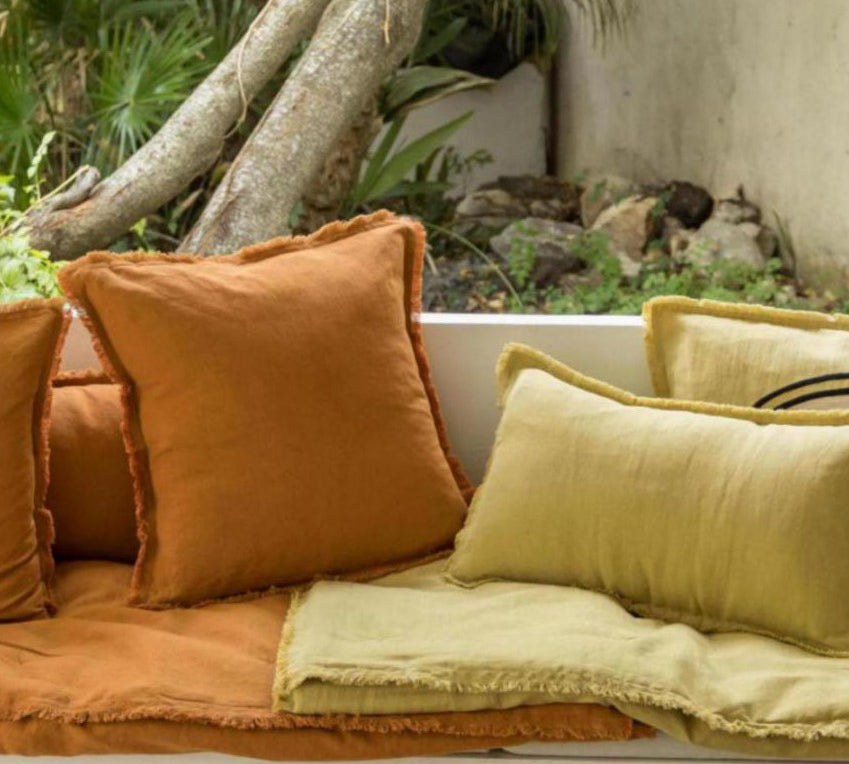 Cozy outdoor seating area with cushions, a small table, and decorative elements.