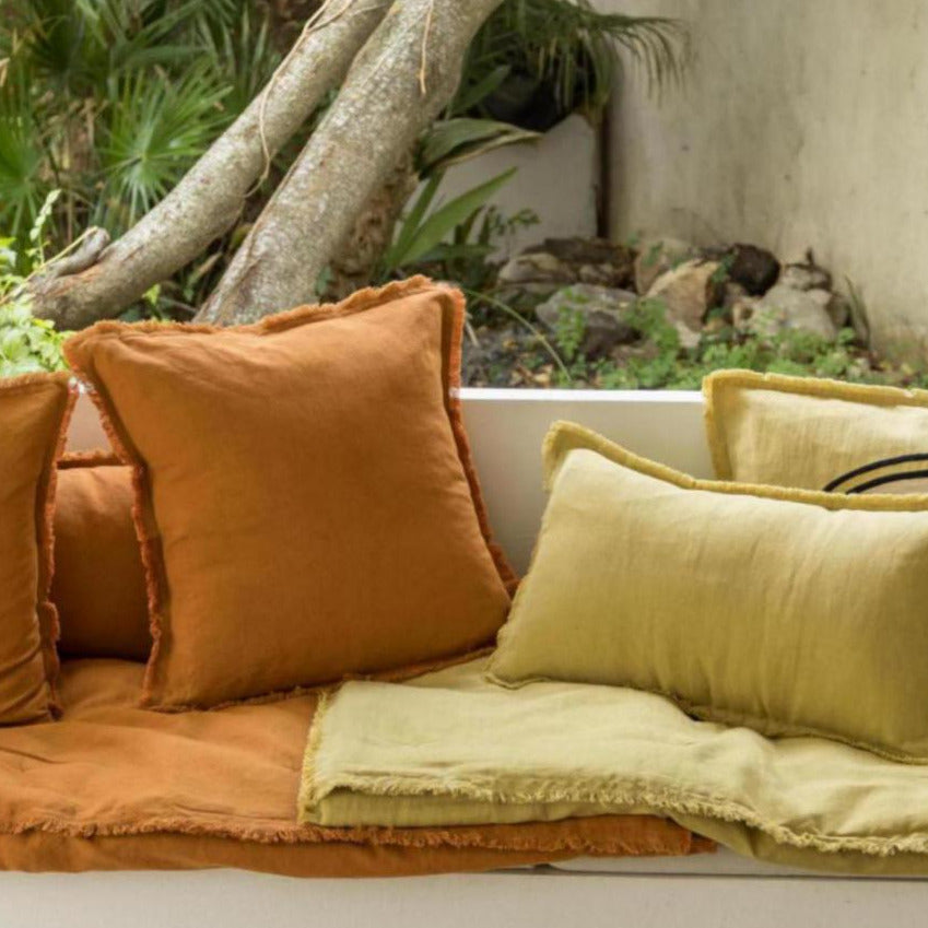 Cozy outdoor seating area with cushions, a small table, and decorative elements.