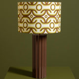 Table lamp with a patterned brown and beige shade on a green background