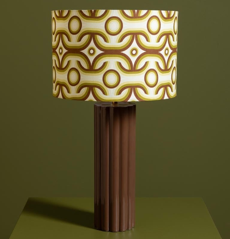 Table lamp with a patterned brown and beige shade on a green background