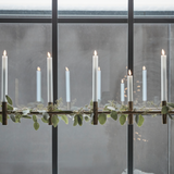 Decorative candle holder with candles in front of a large window