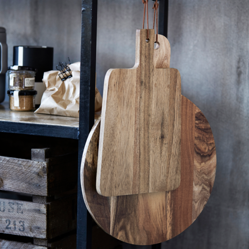 Wooden cutting boards hanging on a wall with a rustic background