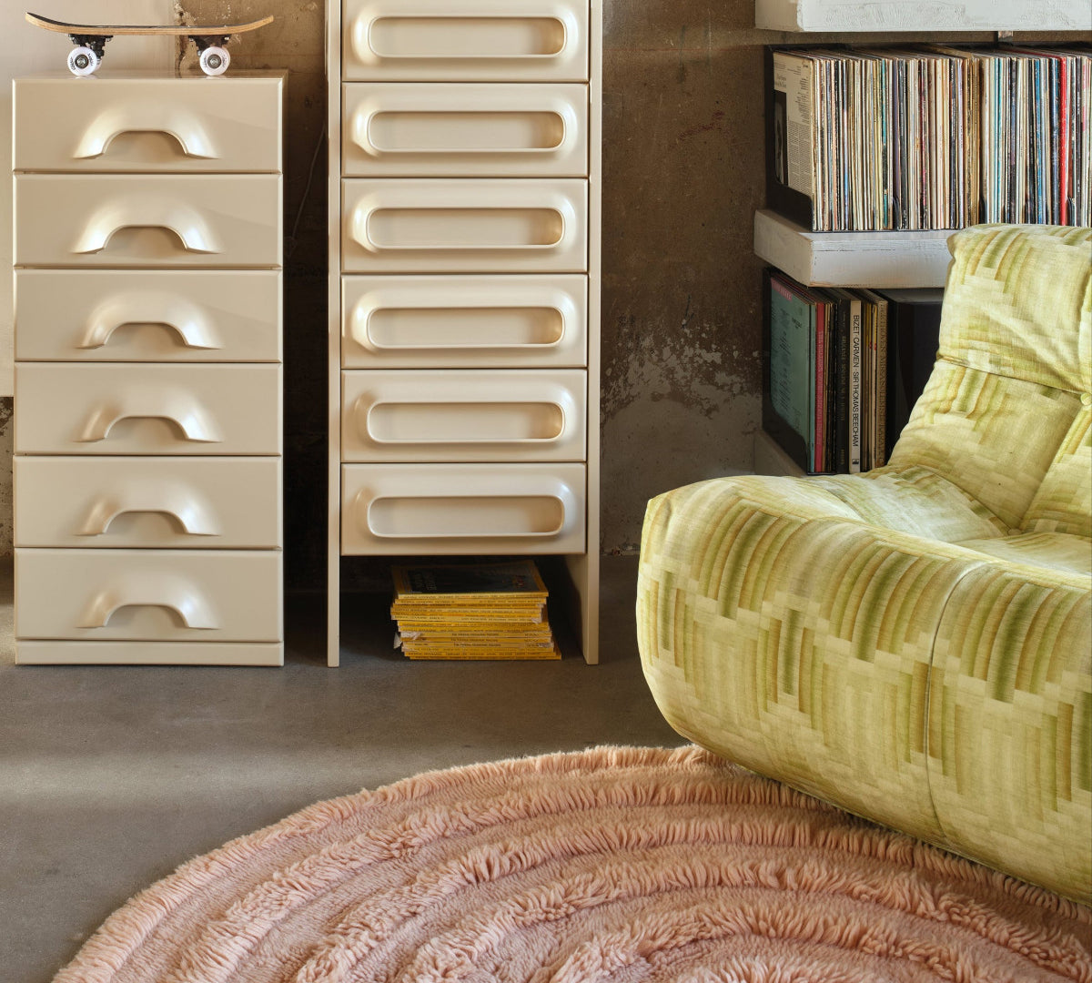 Modern interior with beige drawers, a yellow armchair, and a textured rug.