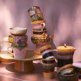 Collection of colorful ceramic items on a pink surface with a soft pink background