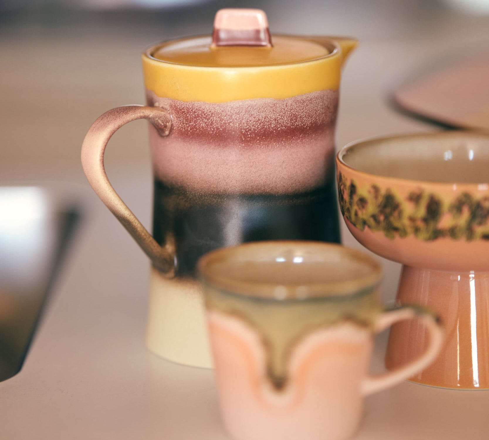 Set of 1970's ceramic teapots and cups on a blurred background