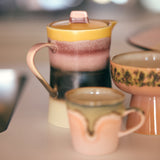 Set of 1970's ceramic teapots and cups on a blurred background