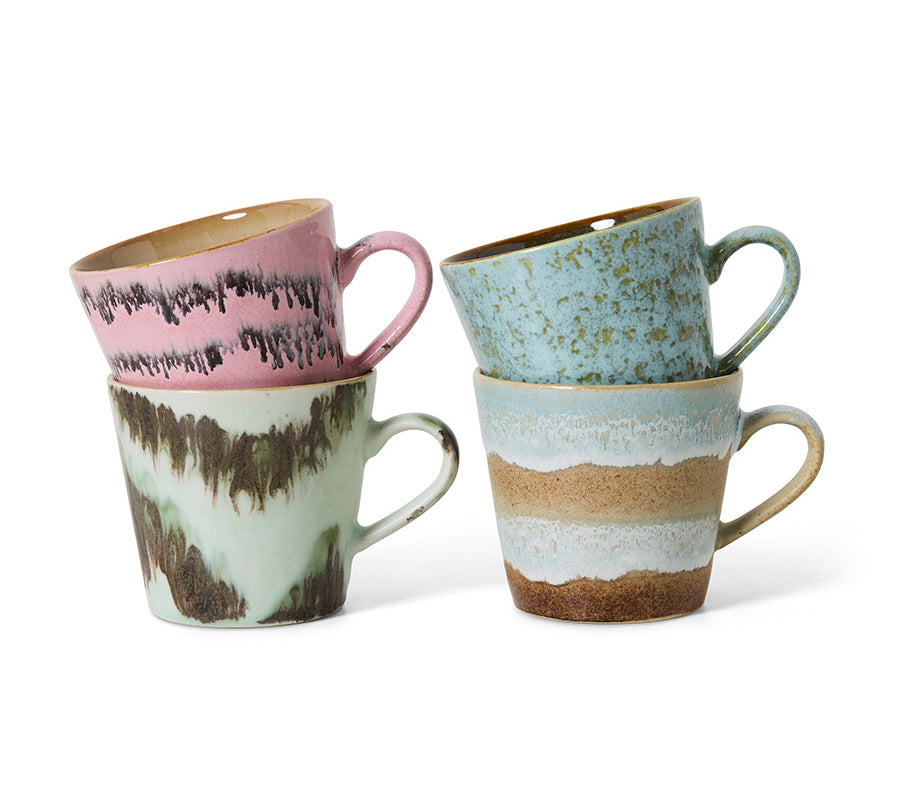 Set of four ceramic mugs with textured, multicolored designs on a white background
