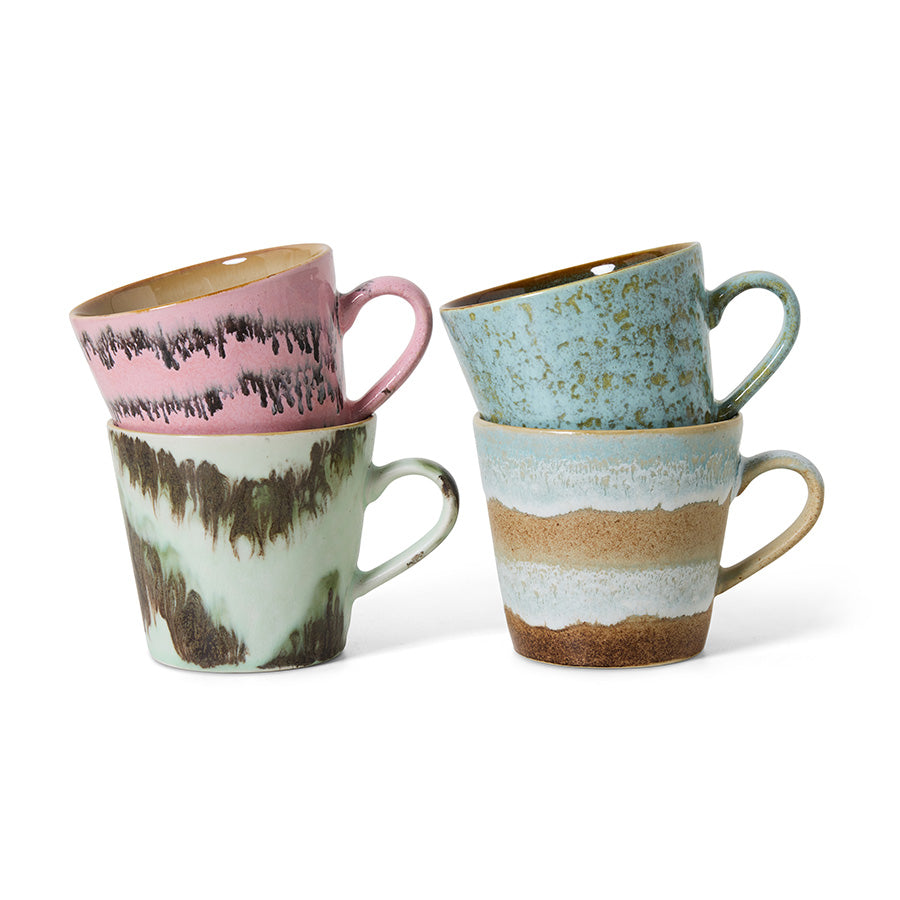 Set of four ceramic mugs with textured, multicolored designs on a white background