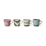 Four ceramic mugs with textured surfaces and different color patterns on a white background