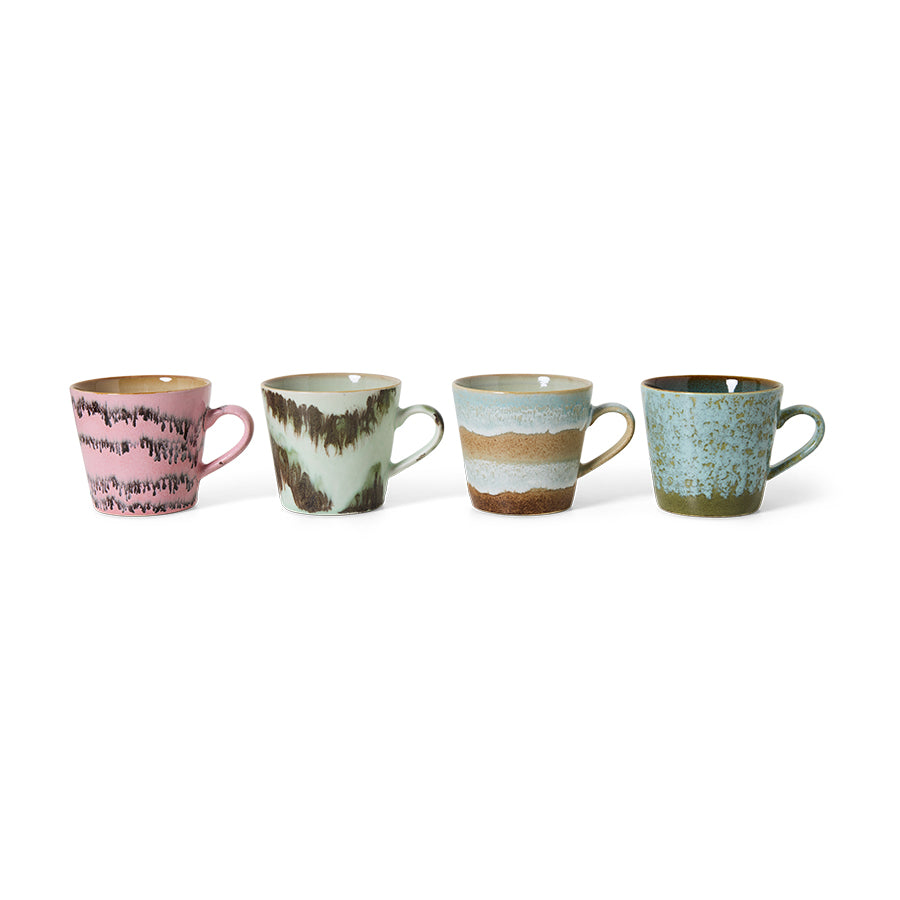 Four ceramic mugs with textured surfaces and different color patterns on a white background