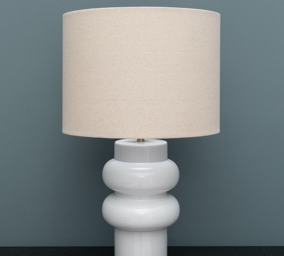 White lamp curve with beige linen shade 