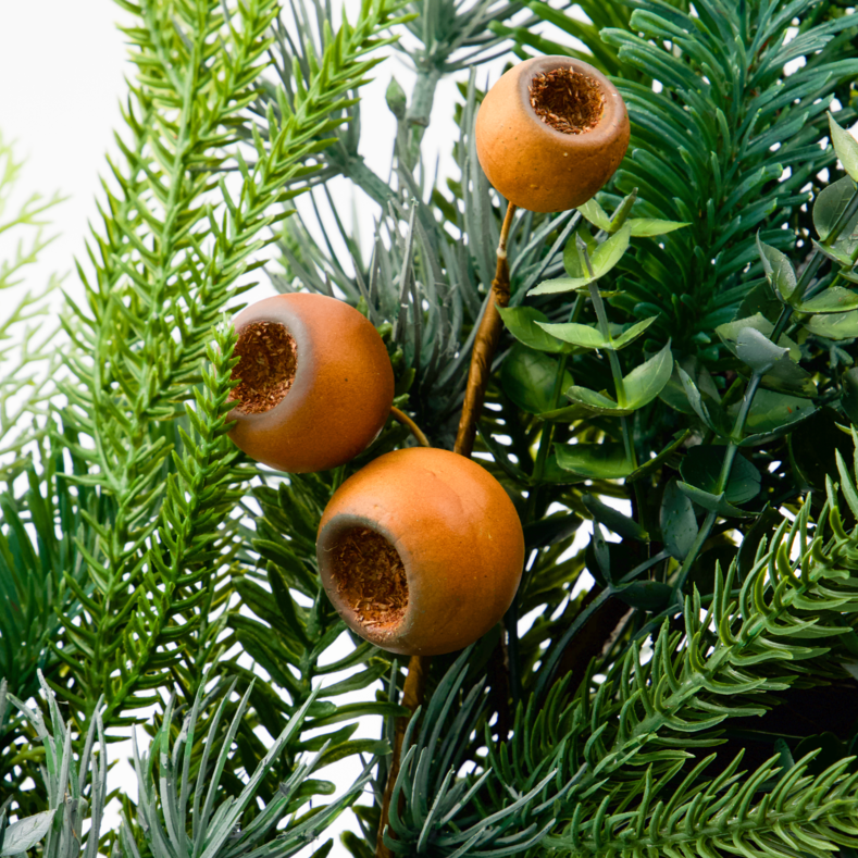 Artificial green foliage with three orange-brown hollow coelacanth-like fruit ornaments attached to stems, photographed against a plain white background.