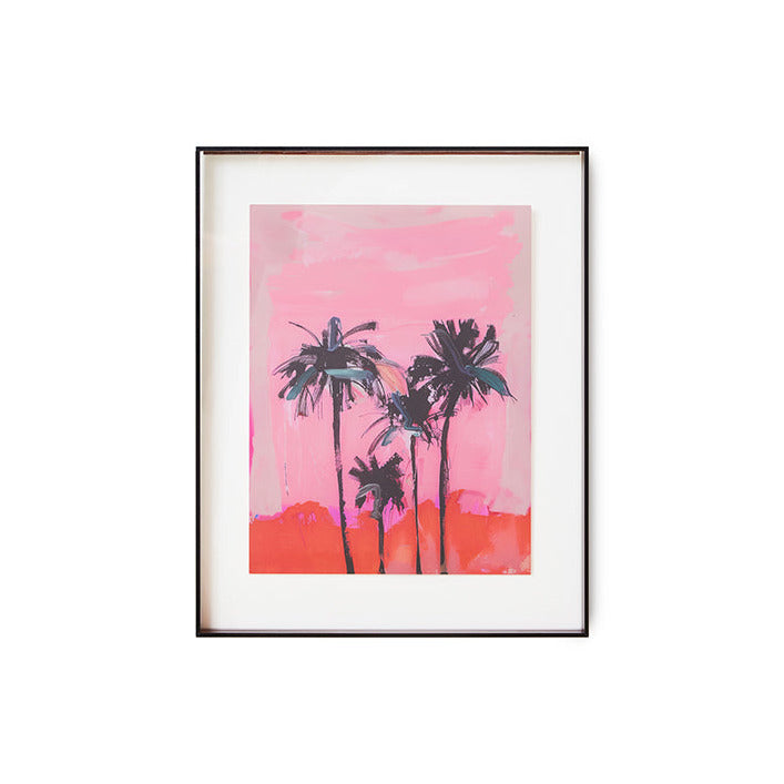 Framed artwork of palm trees against a pink sky on a white background
