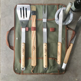 Set of barbecue tools with wooden handles on a green carrying case.