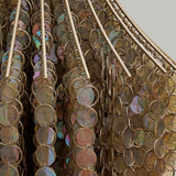 Close-up of a decorative item with circular metallic elements on a plain background