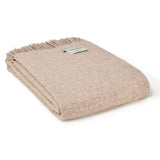 Beige blanket with a brand label on a white background