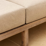 detail of beige cushion on dark wood sofa 