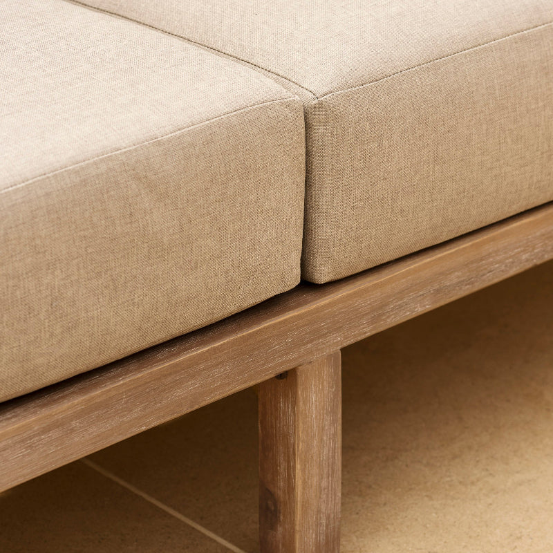 detail of beige cushion on dark wood sofa 
