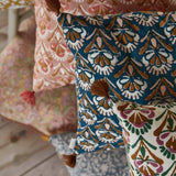 Close-up of patterned cushions with tassels on a wooden surface