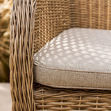 rattan chair with a textured cushion on a blurred natural background