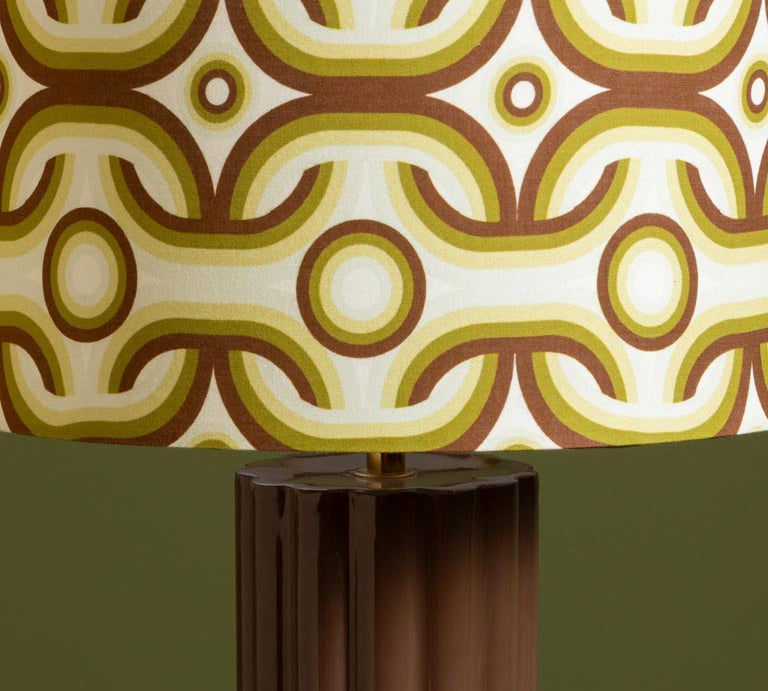 Decorative lamp with a patterned shade on a plain background