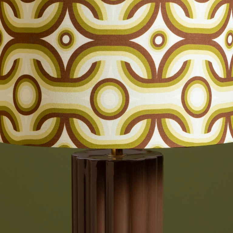 Decorative lamp with a patterned shade on a plain background