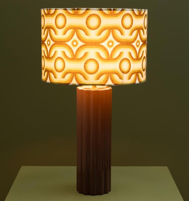 Decorative table lamp with a patterned shade on a dark background