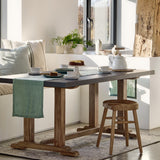 Dining area with wooden table, chairs, and decor in a bright room.