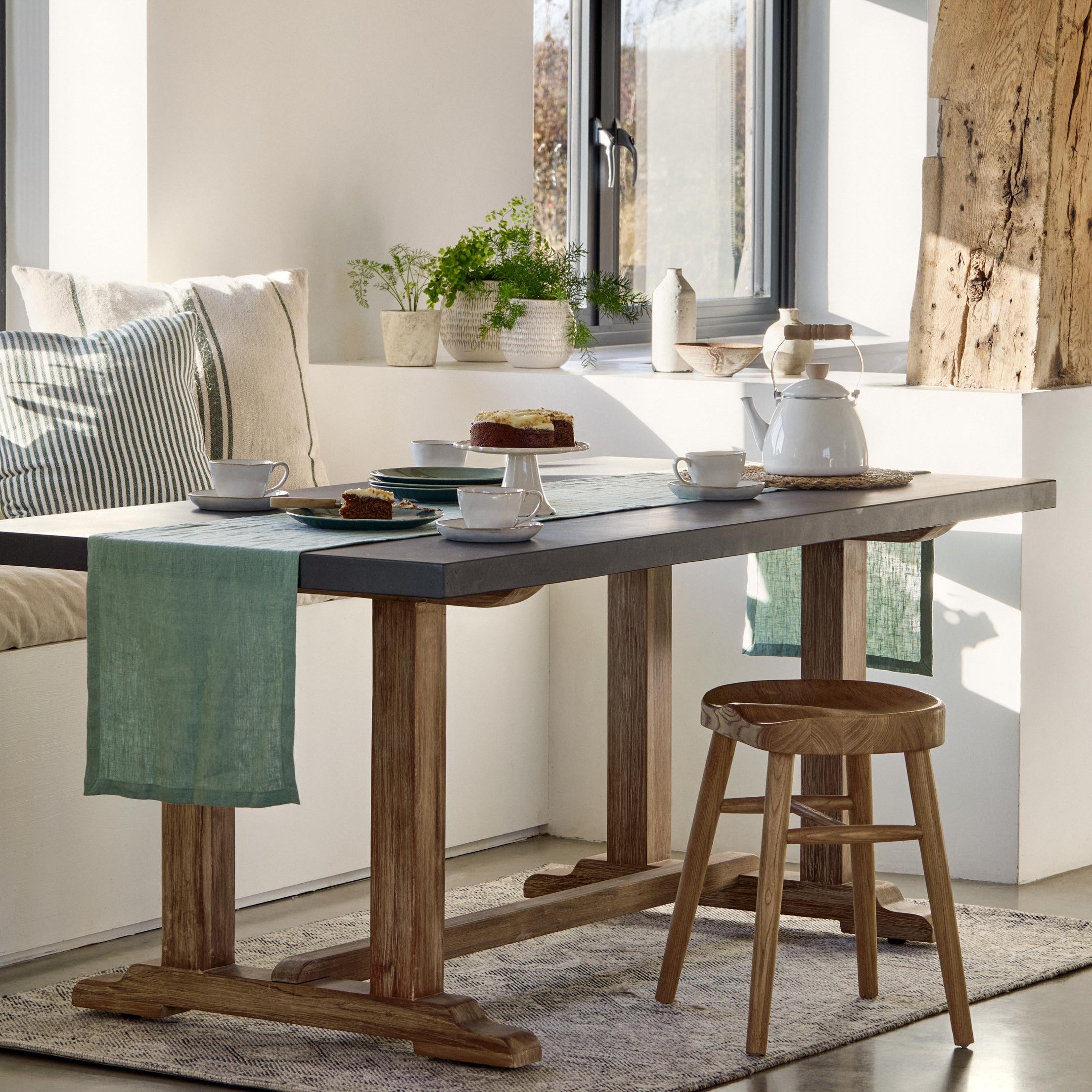Dining area with wooden table, chairs, and decor in a bright room.