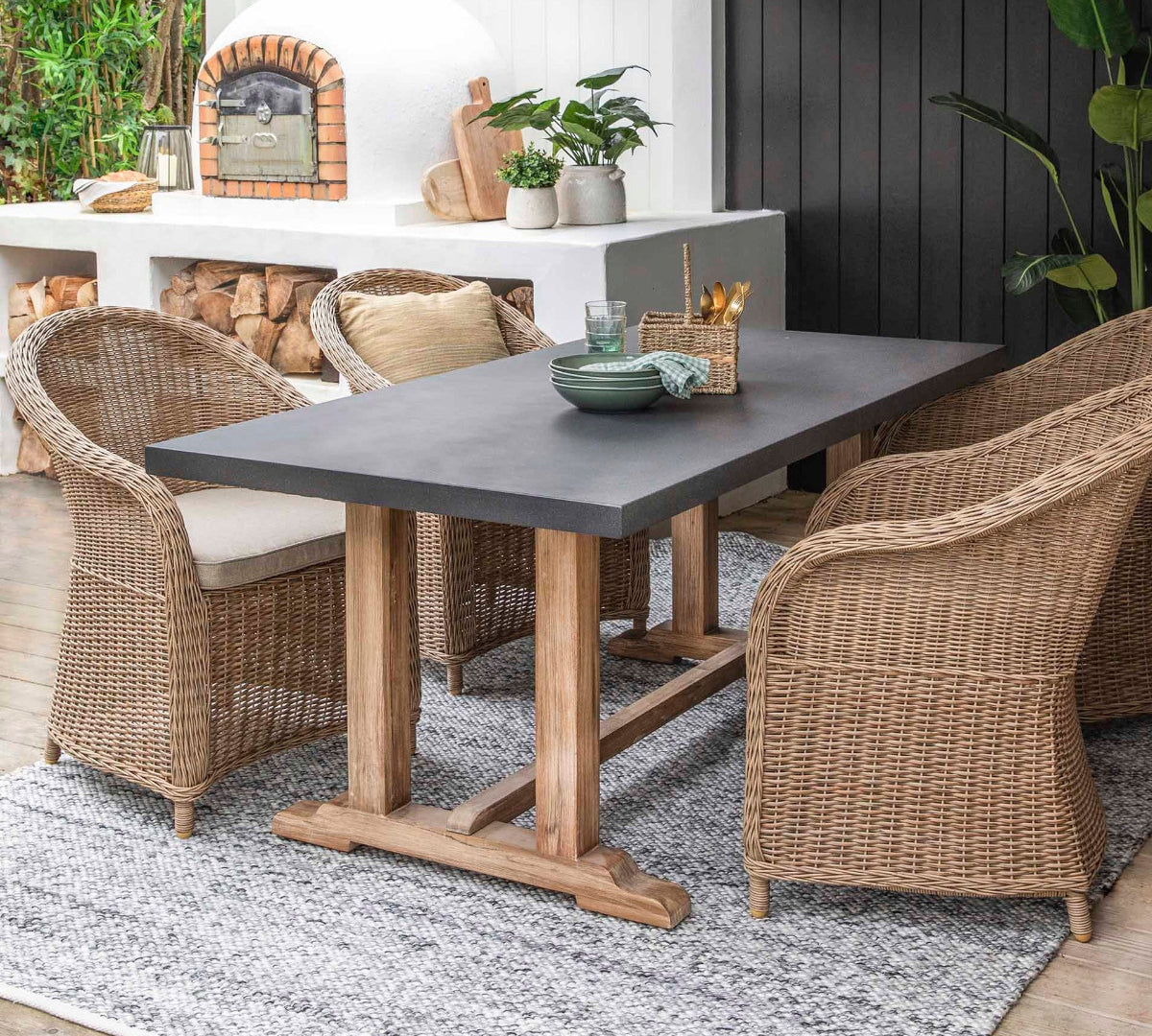 Outdoor dining area with a table and chairs under a pergola.