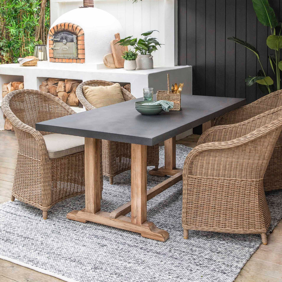 Outdoor dining area with a table and chairs under a pergola.