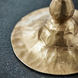 Close-up of a gold candle holder base on a dark surface