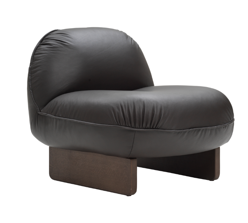 A modern low-profile accent chair with a rounded, bubble-like backrest and seat upholstered in dark charcoal gray leather, supported by a low rectangular dark brown wooden base, shown against a plain white background.