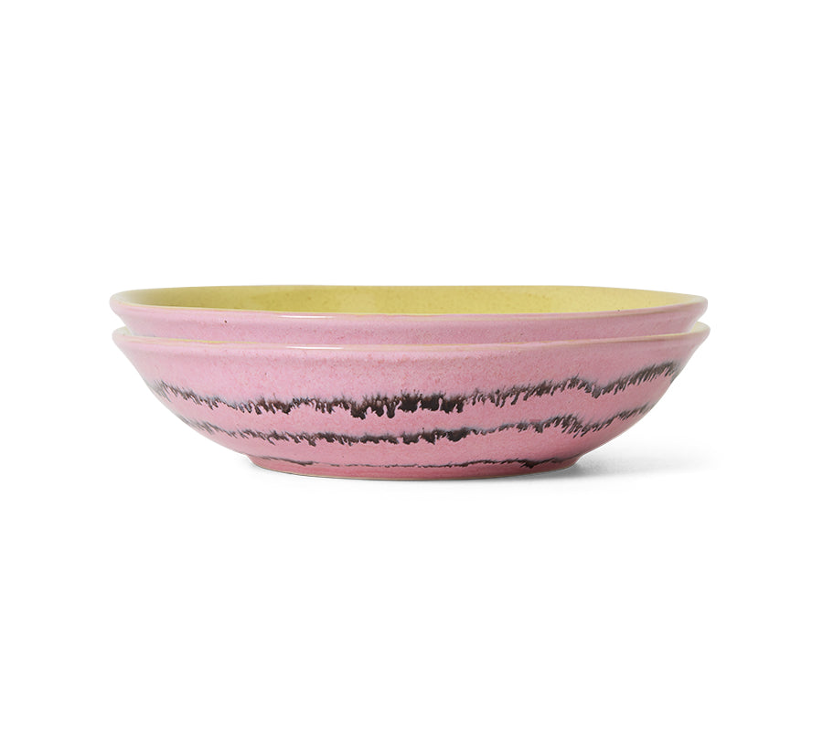 Pink ceramic bowl with black speckles on a white background
