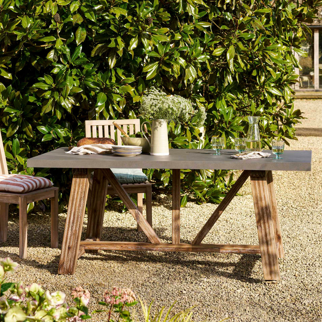 Outdoor dining table set with chairs in a garden setting