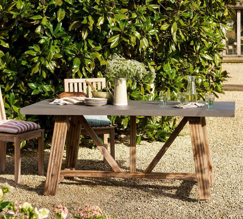 Outdoor dining table set with chairs in a garden setting