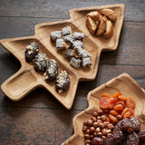 Wooden Christmas Tree shaped platters with dried fruits and nuts on a wooden surface