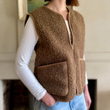 woman wearing a brown fleece wool vest indoors