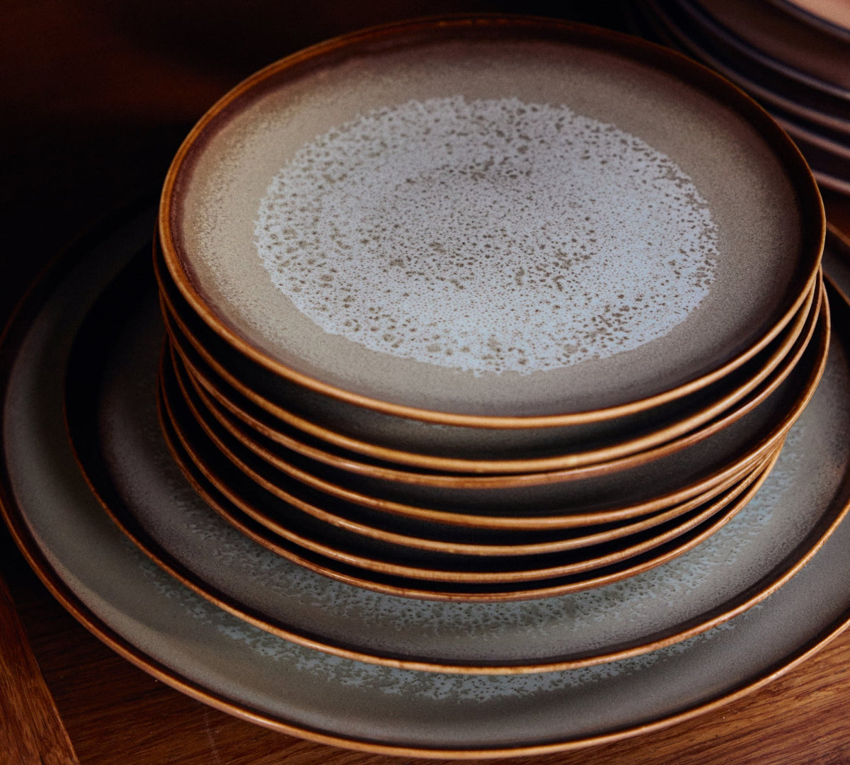 Stack of ceramic plates with a textured surface on a wooden surface