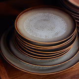 Stack of ceramic plates with a textured surface on a wooden surface
