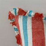 Close-up of coral stripe linen cushion fringe ruffle edge detail showing raw linen fraying in coral, aqua and white