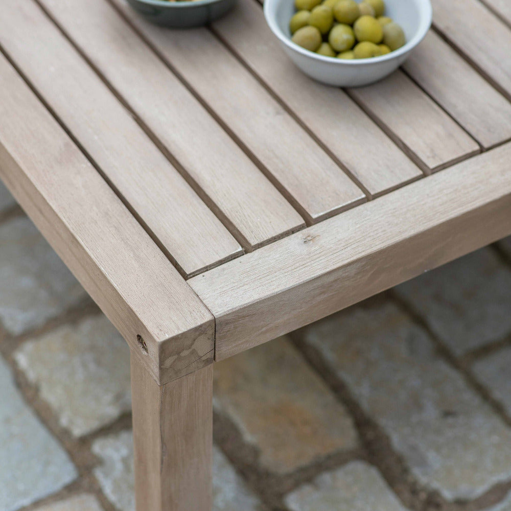 Wooden table with bowls of snacks on a stone patio