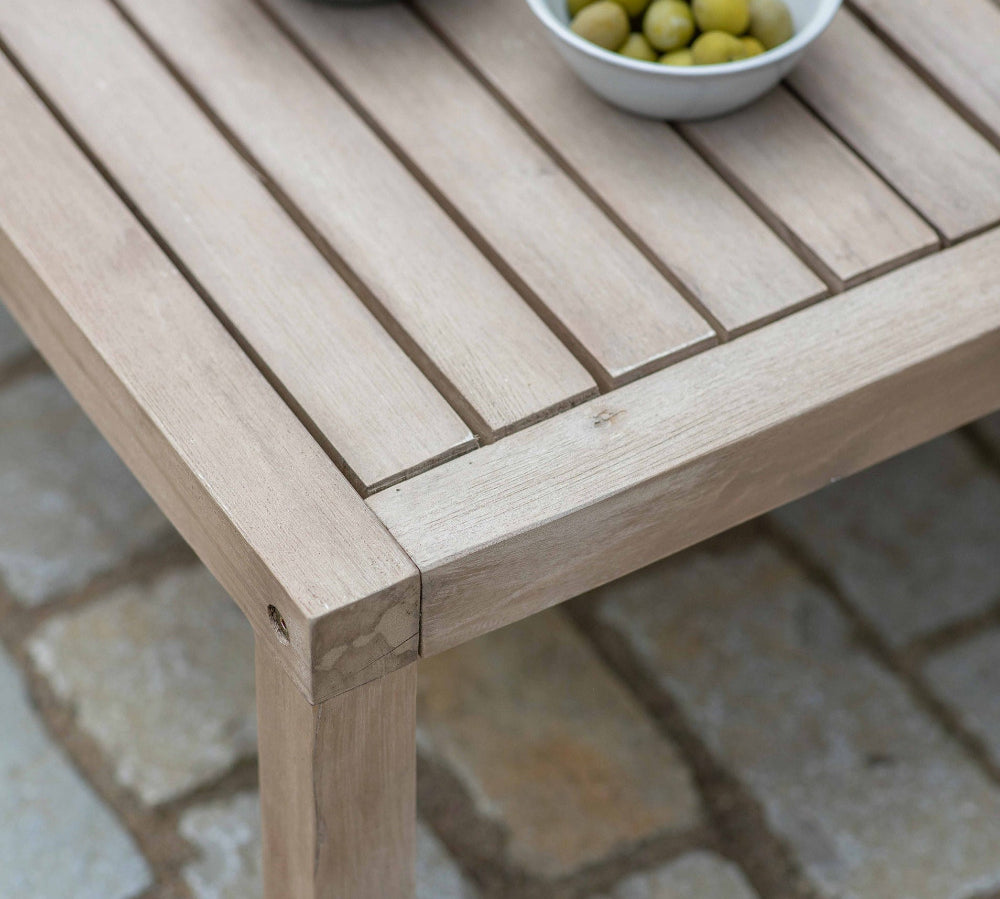 Wooden table with bowls of snacks on a stone patio