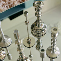 Silver candlestick holders on a reflective surface