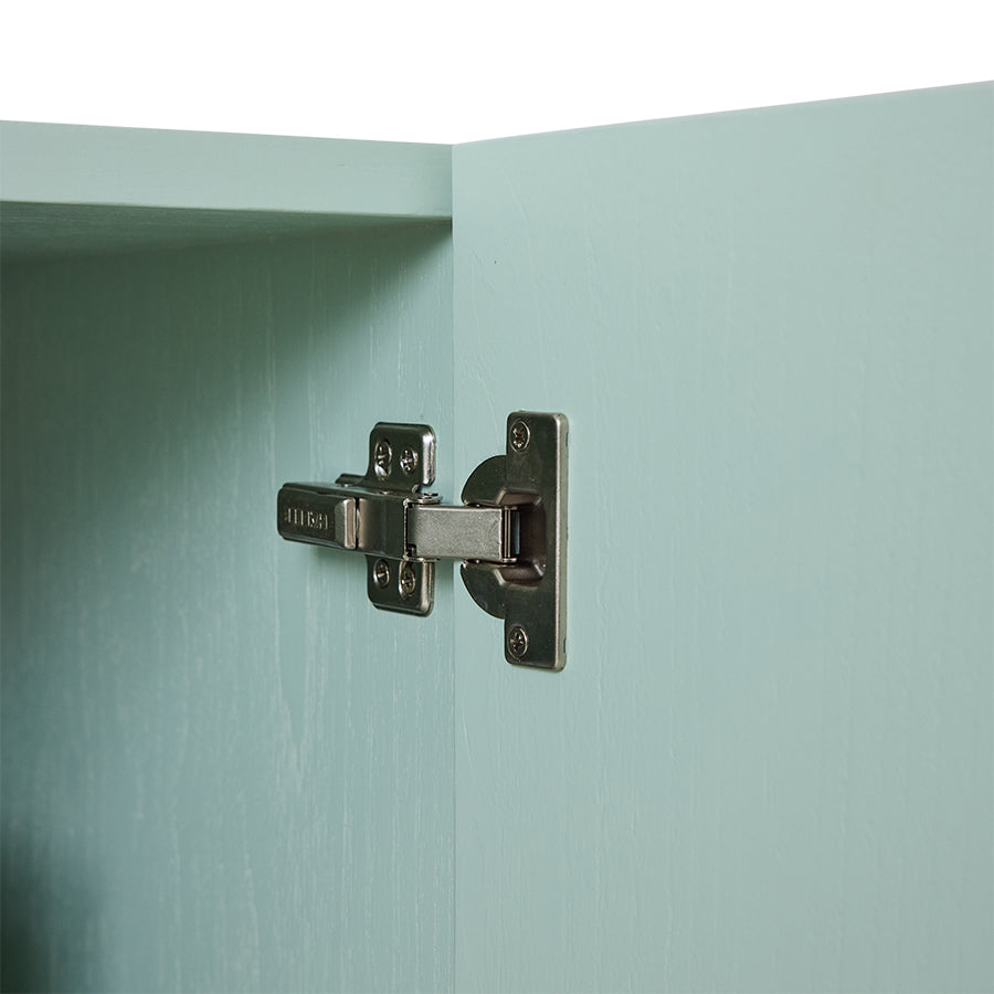 Cabinet hinge on a light blue cabinet door