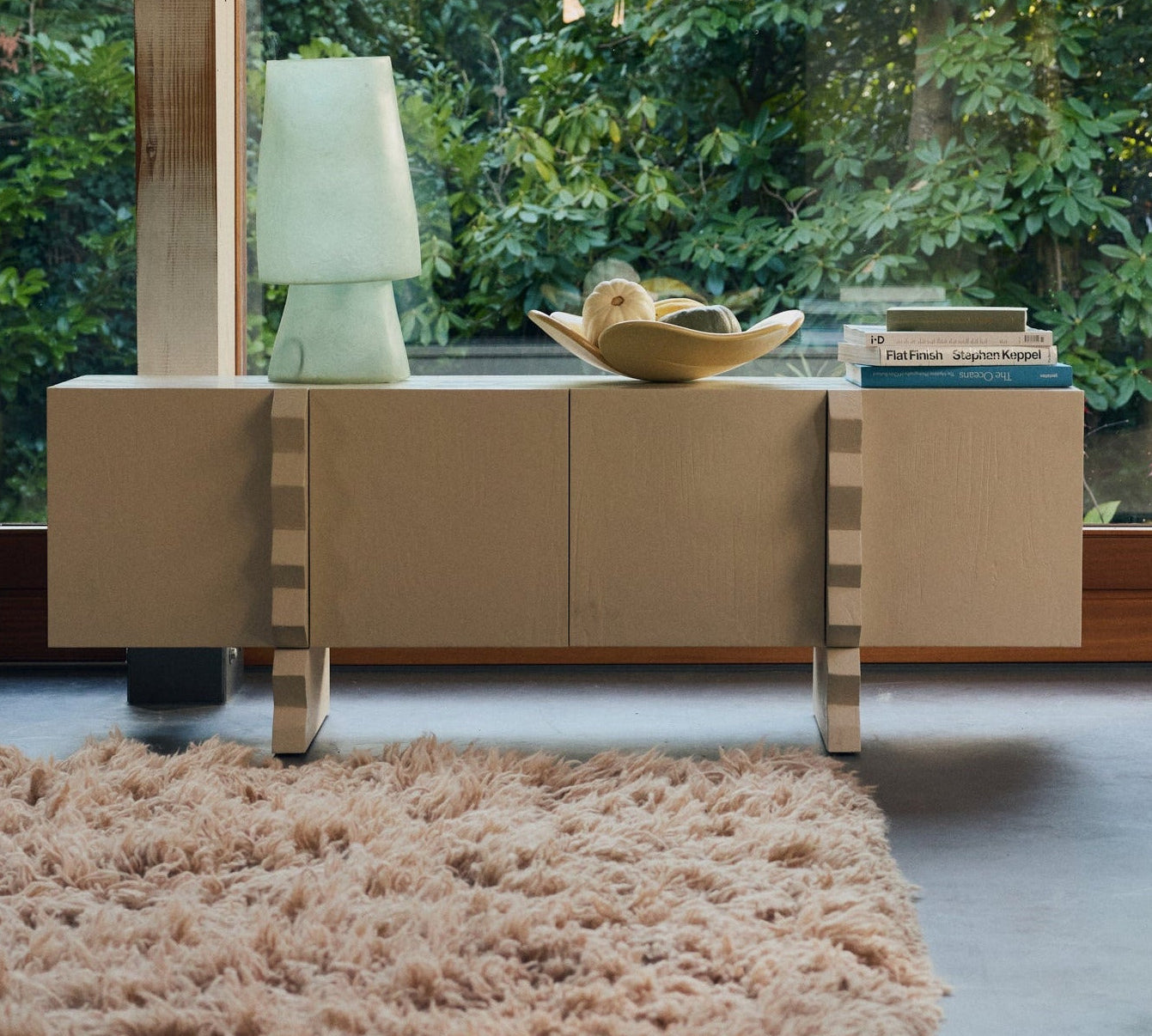Modern interior with a large window side cabinet and lamp