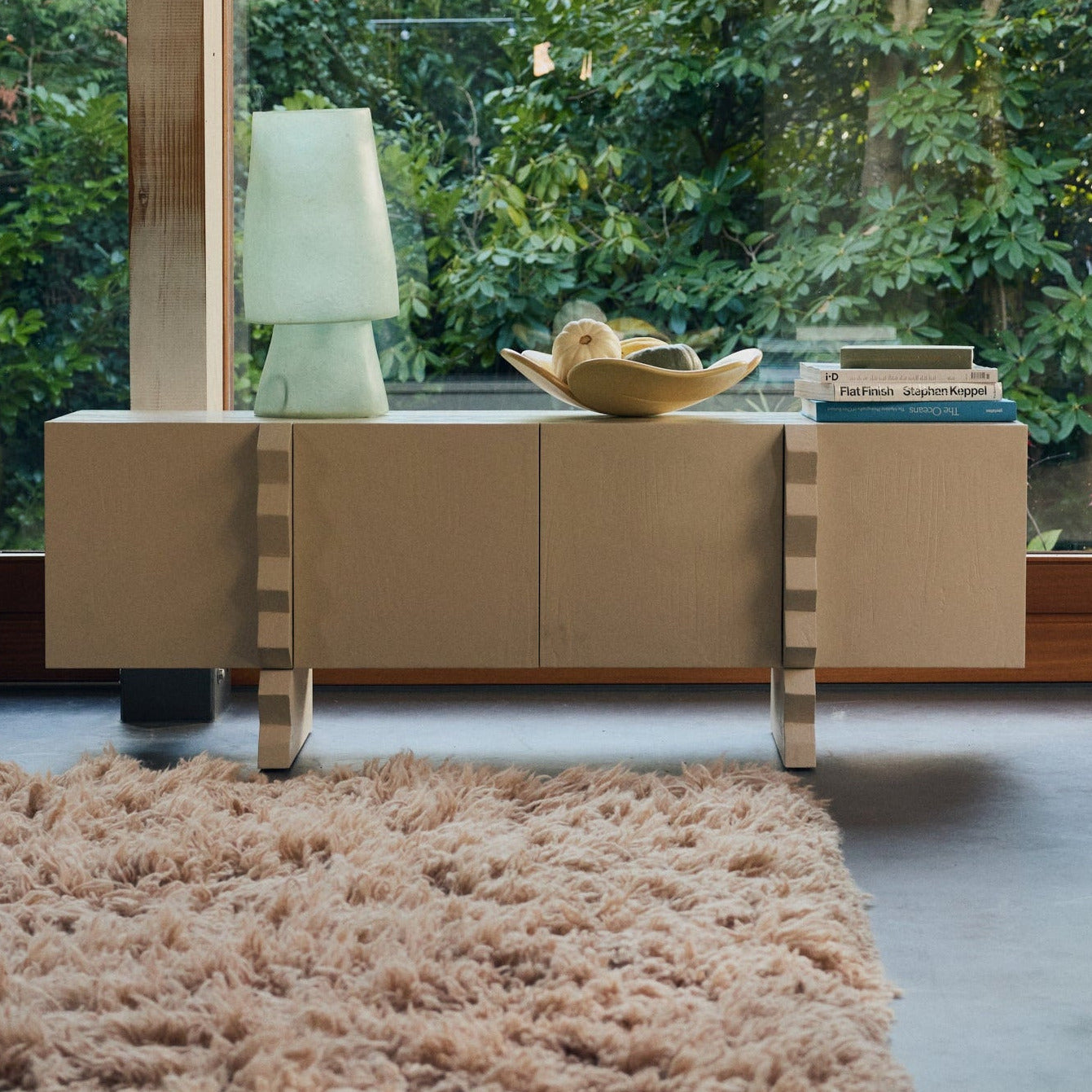 Modern interior with a large window side cabinet and lamp