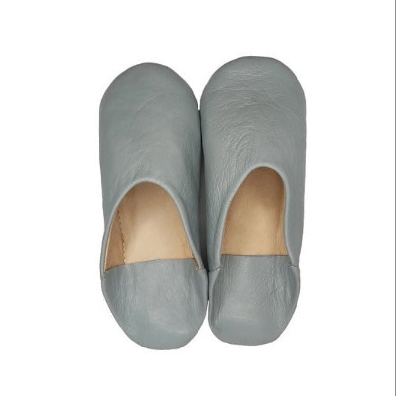 A pair of light gray leather slip-on shoes with a natural beige interior lining, shown from a top-down view on a white background.